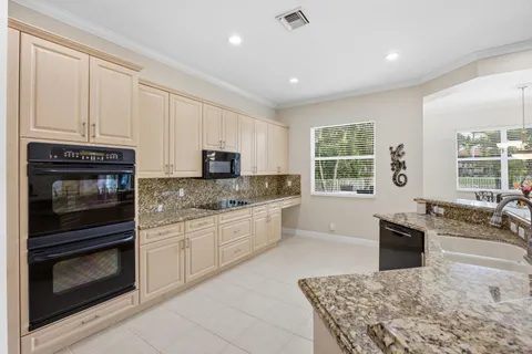 a kitchen with refrigerator and chairs