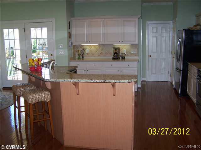 13343 Tipple Point Road Midlothian, VA 23114 - Photo 6 of 12 a view of a kitchen with a sink wooden cabinets and a living room