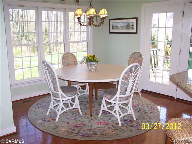 13343 Tipple Point Road Midlothian, VA 23114 - Photo 7 of 12 a dining room with wooden floor a chandelier a wooden table and chairs