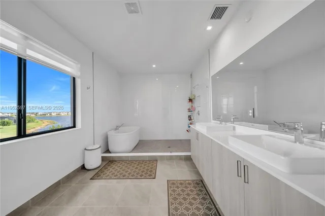 a spacious bathroom with a double vanity sink toilet and a tub