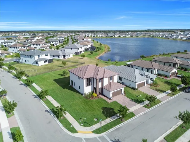 an aerial view of residential houses with outdoor space and ocean