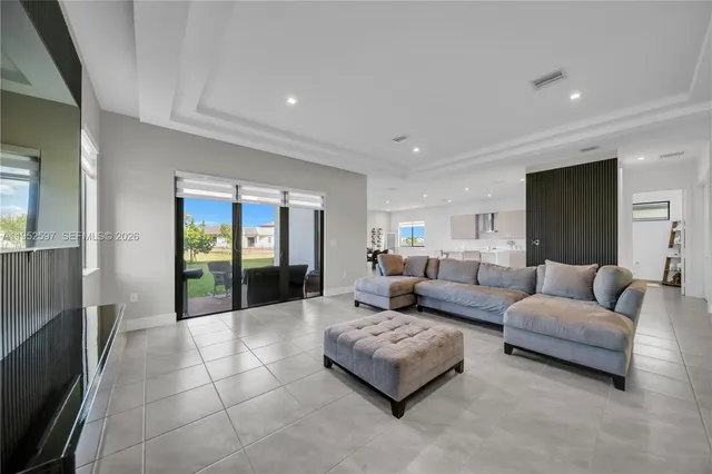 a living room with furniture and large glass door