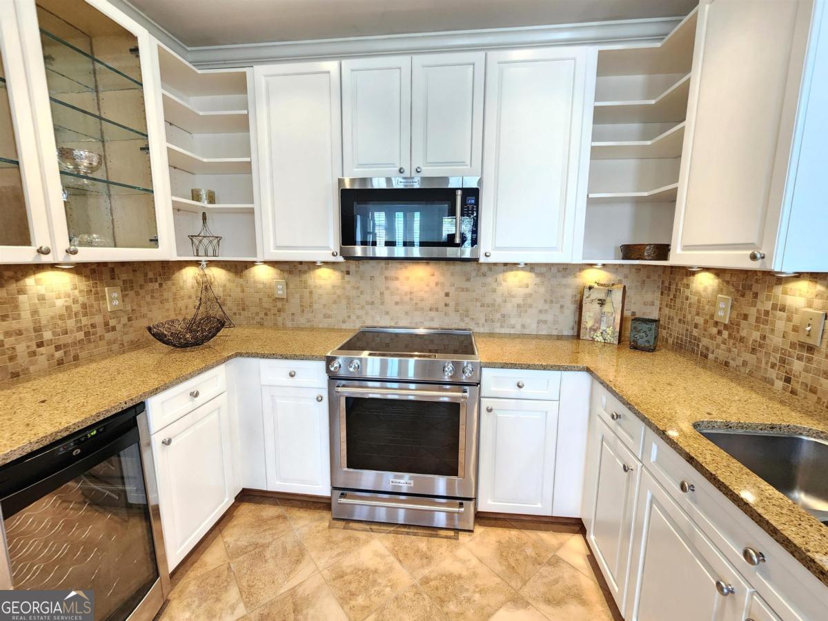 109 (unit 1203) South Bay Road Eatonton, GA 31024 - Photo 17 of 55 a kitchen with stainless steel appliances granite countertop a stove a sink and a microwave