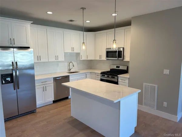 a kitchen with stainless steel appliances granite countertop a refrigerator and a stove top oven