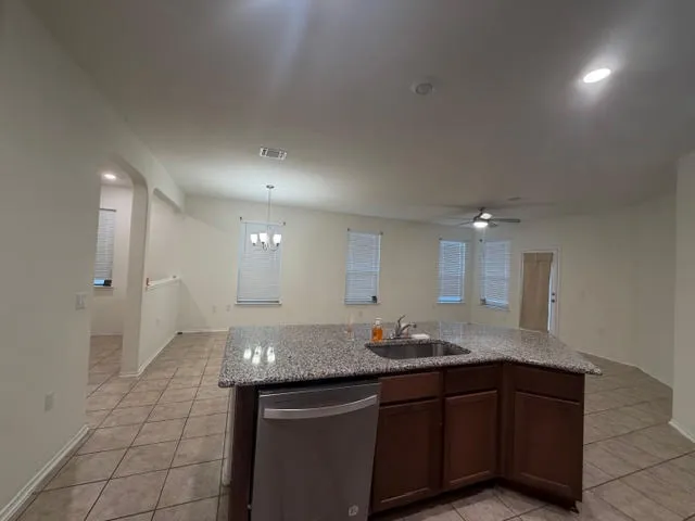 a view of a kitchen with kitchen island stainless steel appliances a chandelier open kitchen view