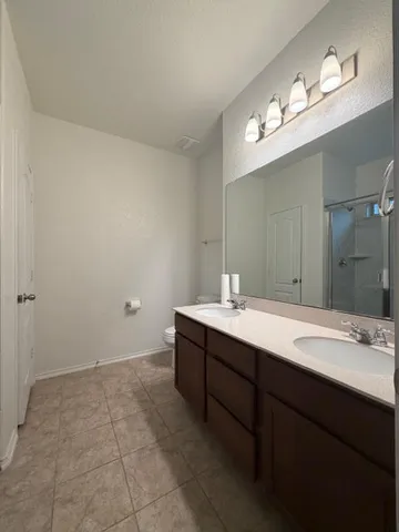 a bathroom with a granite countertop sink a toilet and a mirror