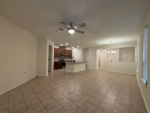 a view of kitchen with granite countertop lots of white cabinets a sink and stainless steel appliances