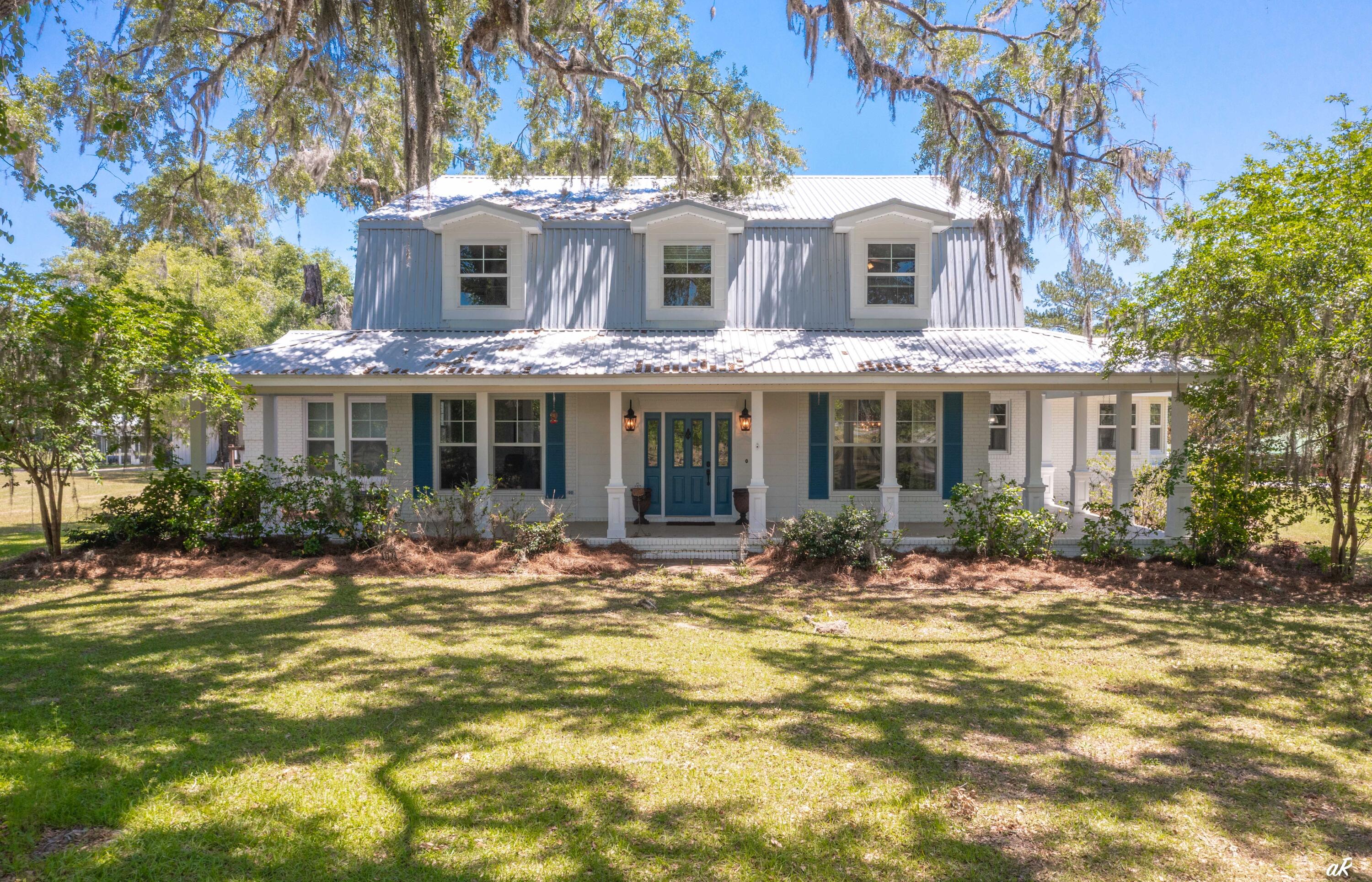 a front view of a house with yard outdoor seating and retail shops