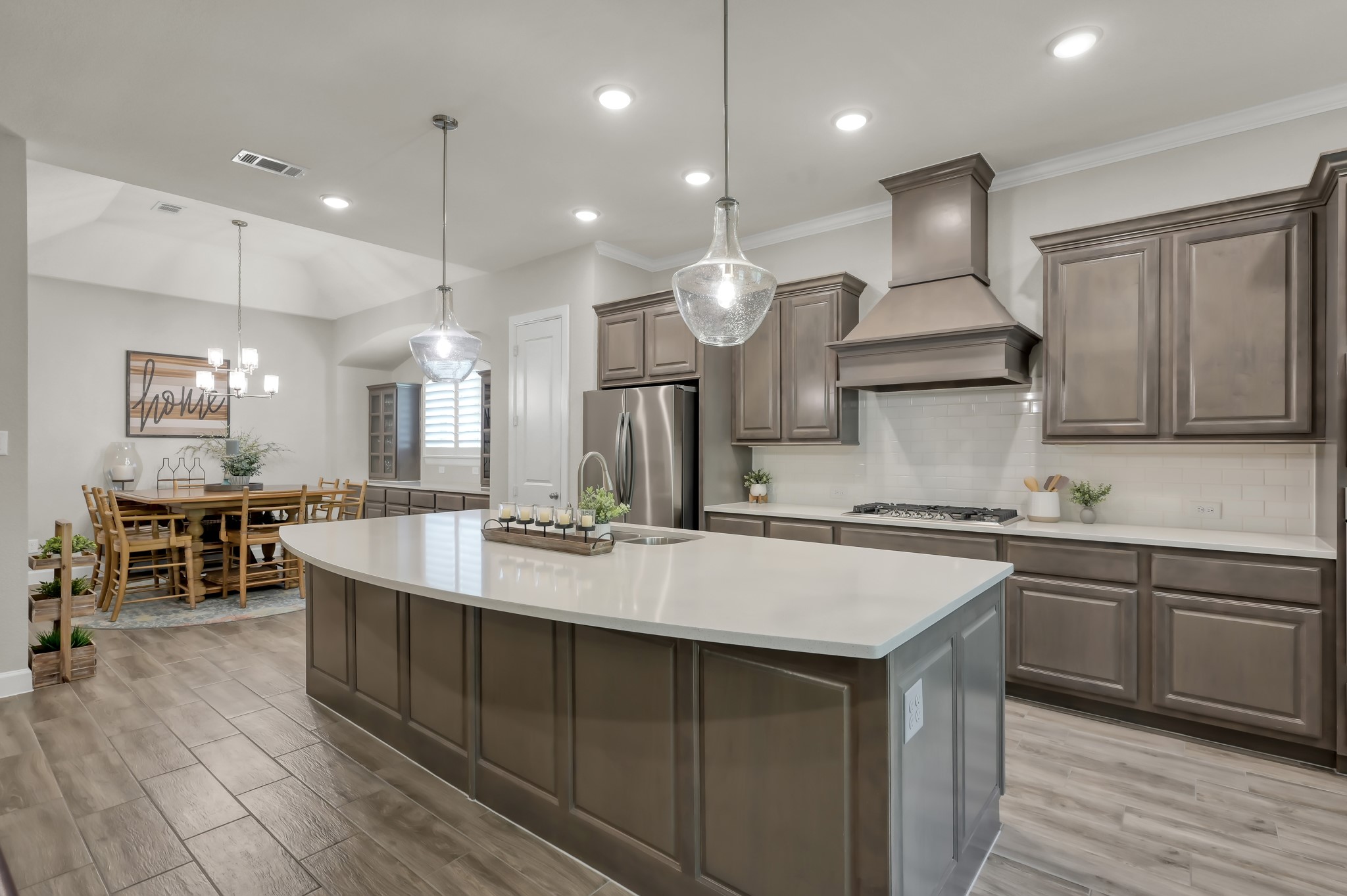 334 Torrey Bloom Loop Conroe, TX 77304 - Photo 16 of 47 Stunning island kitchen with quartz countertops, pendant lighting, stainless steel appliances, and ample cabinetry—open to dining for seamless entertaining.