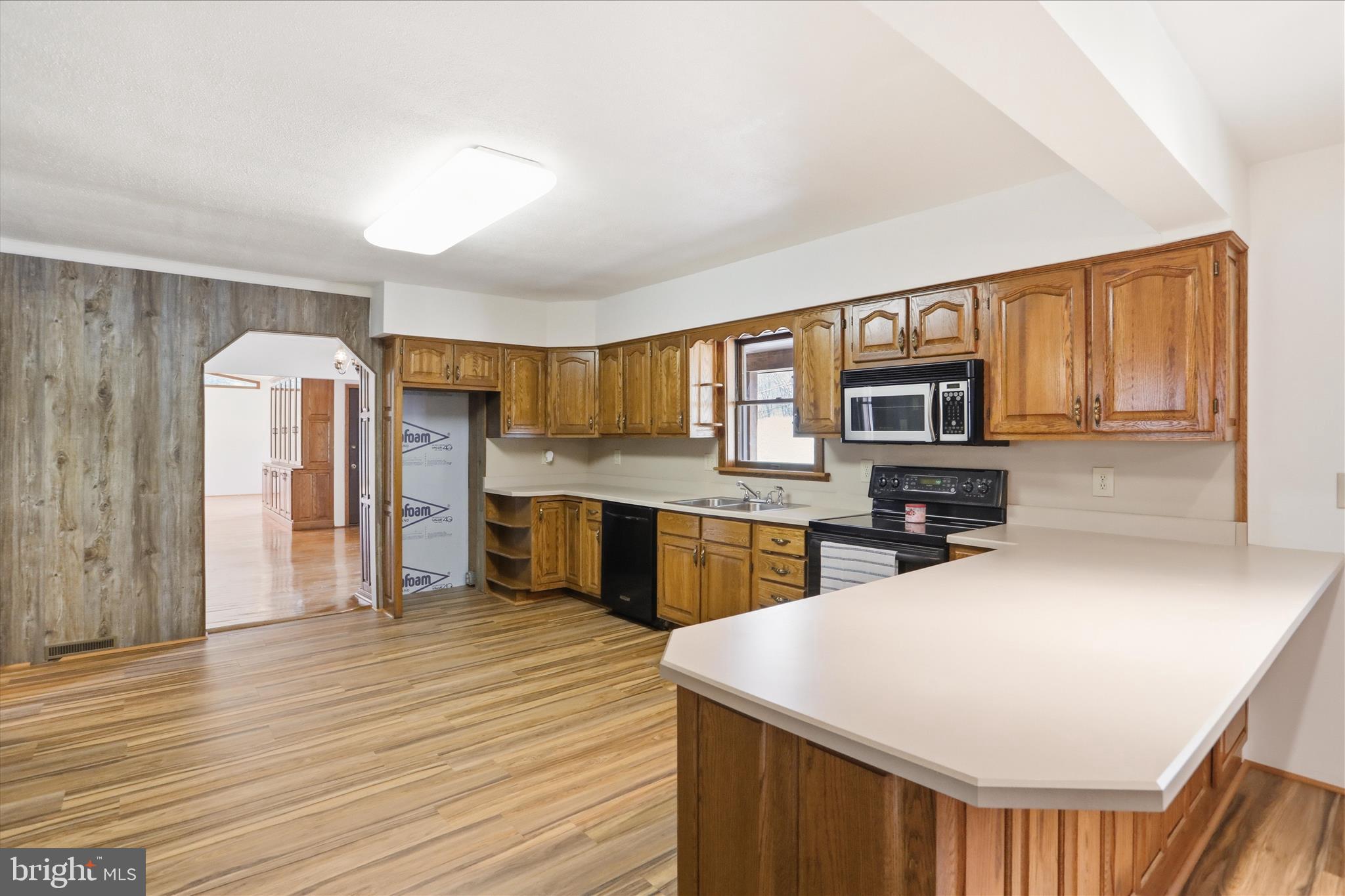 12623 Windy Ridge Drive Mount Savage, MD 21545 - Photo 21 of 72 a living room with stainless steel appliances kitchen island granite countertop a refrigerator a stove a sink dishwasher and wooden cabinets with wooden floor