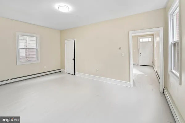 an empty room with windows and closet