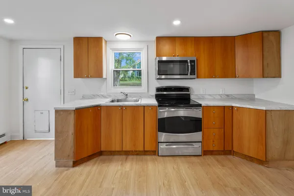 a view of kitchen with wooden floor and electronic appliances