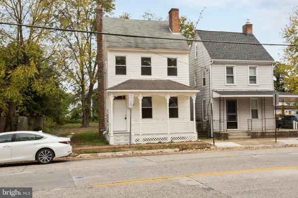 a view of a white car parked in front of a house
