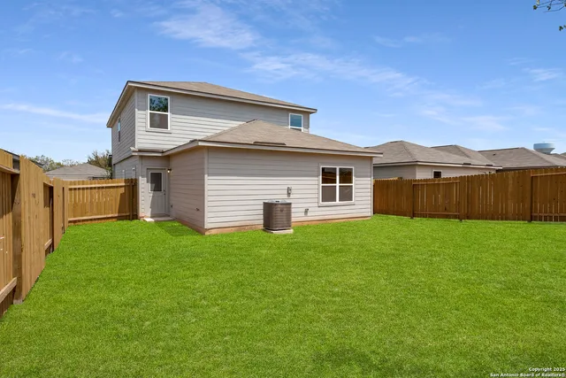 a view of a yard in front of a house with large tree