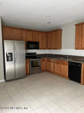 a kitchen with stainless steel appliances granite countertop a stove top oven a sink and dishwasher