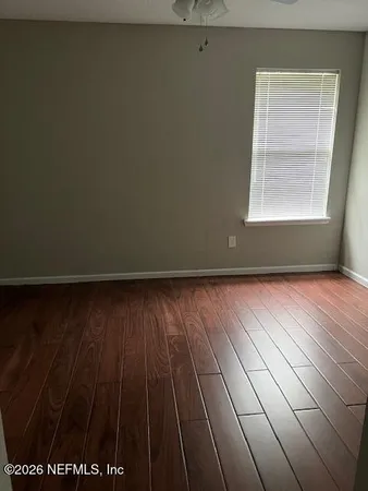 a view of a room with wooden floor and windows
