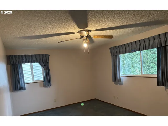 a view of a livingroom with a ceiling fan and a window