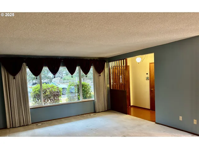 a view of an empty room with a fireplace and a window