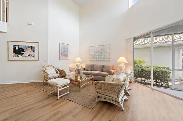a living room with furniture and a large window with wooden floor