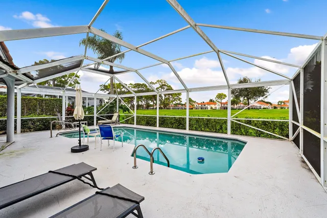 a view of a swimming pool with a porch and furniture