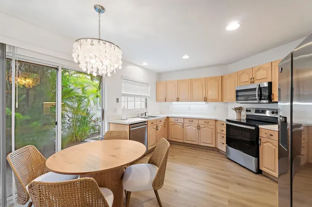 a kitchen with stainless steel appliances granite countertop a kitchen island hardwood floor sink stove dining table and chairs