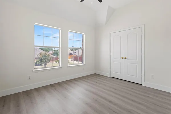 an empty room with wooden floor and window