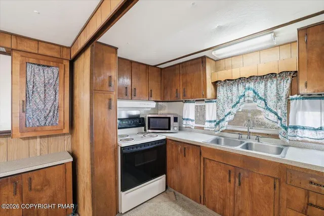 a view of a elevator and an empty room with wooden floor