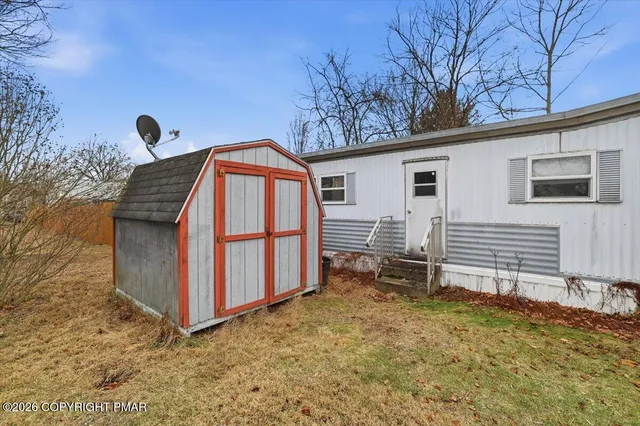 a backyard of a house with table and chairs