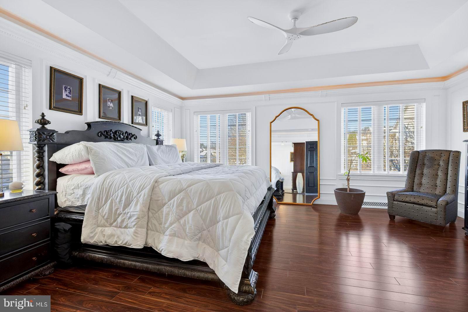 1098 Stillwood Circle Lititz, PA 17543 - Photo 23 of 46 a spacious bedroom with a bed a couch and a large window with wooden floor