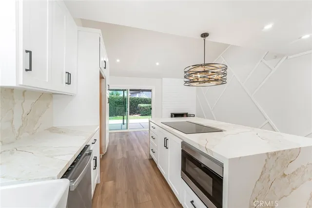 a kitchen that has a lot of cabinets in it and wooden floors