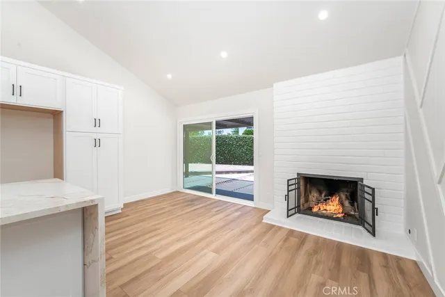a large white kitchen with a large window stainless steel appliances and cabinets