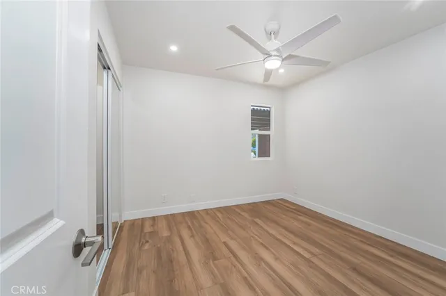 an empty room with a window and closet area