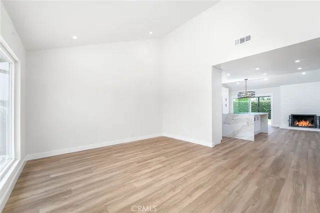 a large white kitchen with a stove a sink a refrigerator and a fireplace