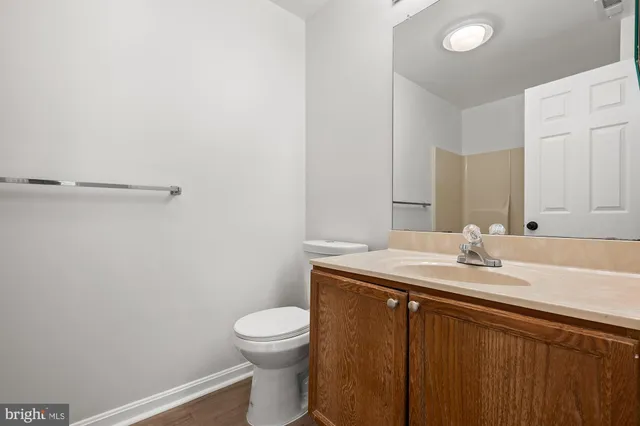 a bathroom with a granite countertop sink toilet and mirror