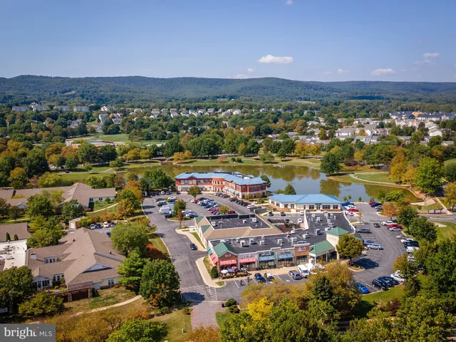 an aerial view of ocean and residential houses with outdoor space