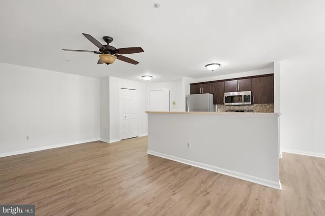 a view of a kitchen with wooden floor and stainless steel appliances