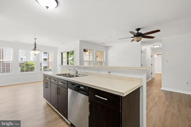 a kitchen with a sink and a stove with wooden floor