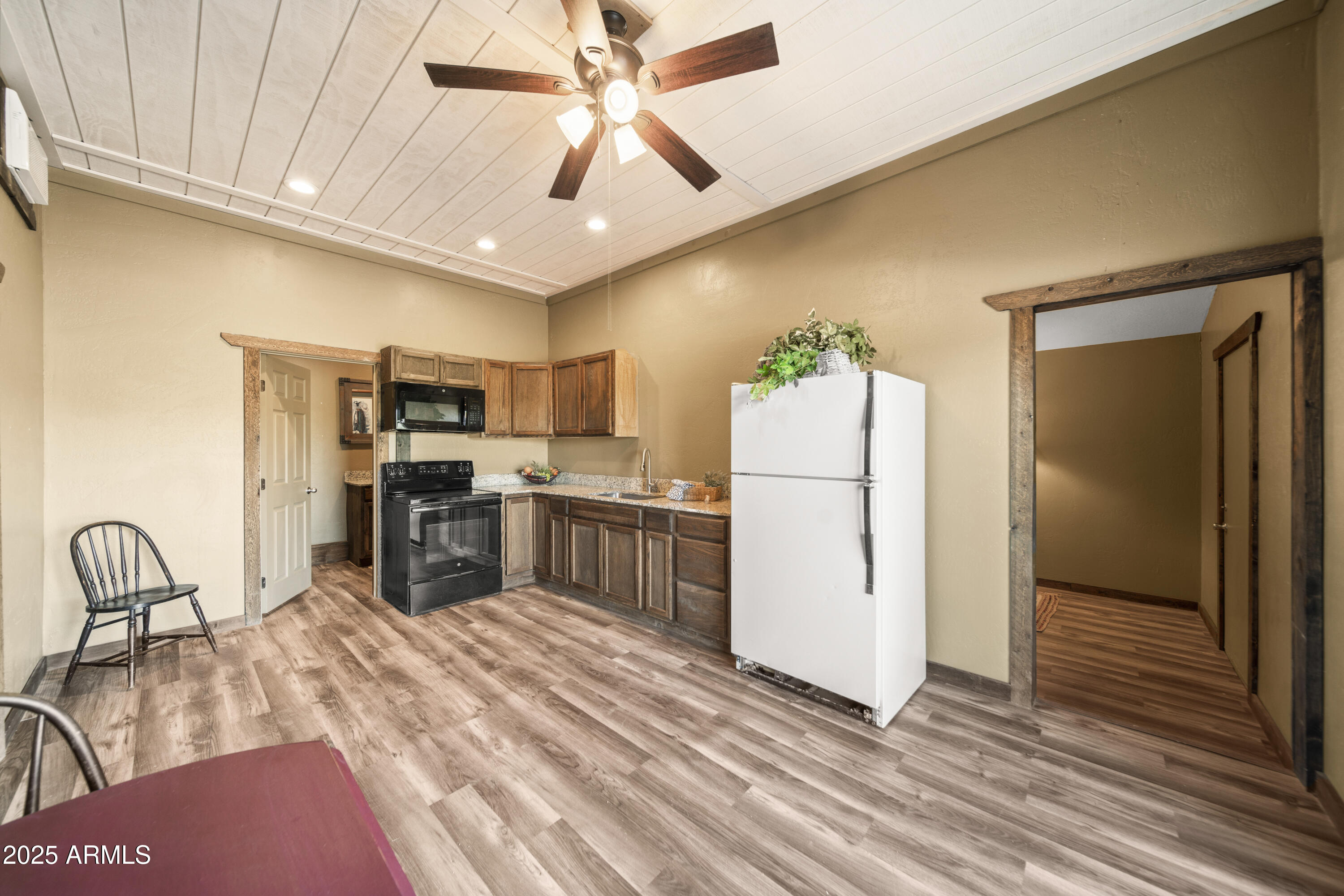 18330 Moonlight Mesa Road Wickenburg, AZ 85390 - Photo 17 of 31 a kitchen with a refrigerator a stove cabinets and wooden floor