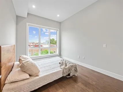 a bedroom with a bed and a large window