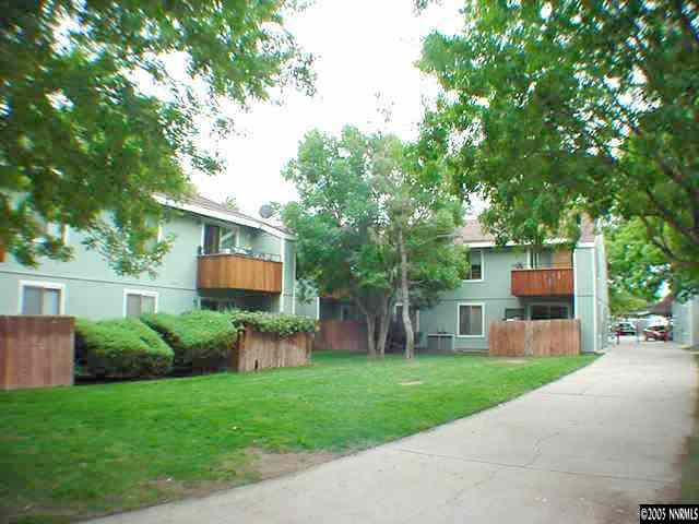 a front view of a house with a garden and trees