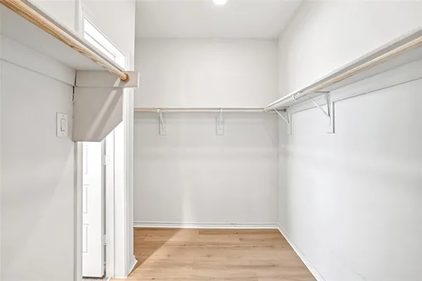 a view of walk in closet with empty racks