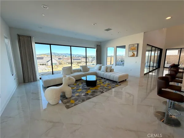 a living room with furniture and large windows