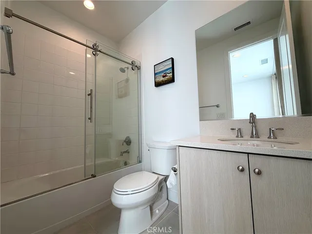 a bathroom with a toilet a sink a mirror and shower