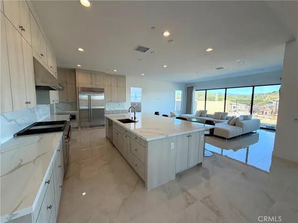 a large white kitchen with a large window and a counter top space