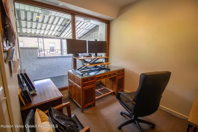a view of a workspace with furniture and a window