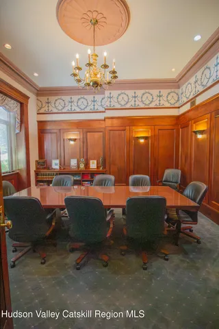 a living room with furniture a chandelier and a rug