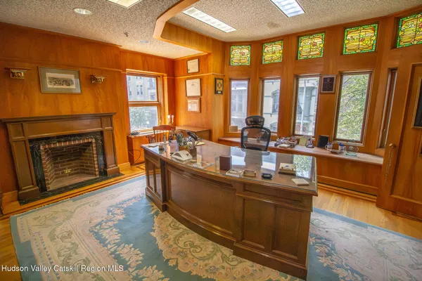 a dining hall with stainless steel appliances granite countertop a stove and a wooden floors