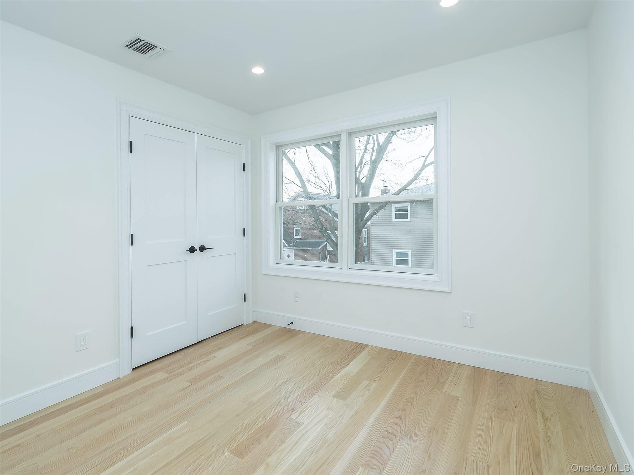 35 B Dunwood Road Port Washington, NY 11050 - Photo 23 of 35 a view of an empty room with wooden floor and a window