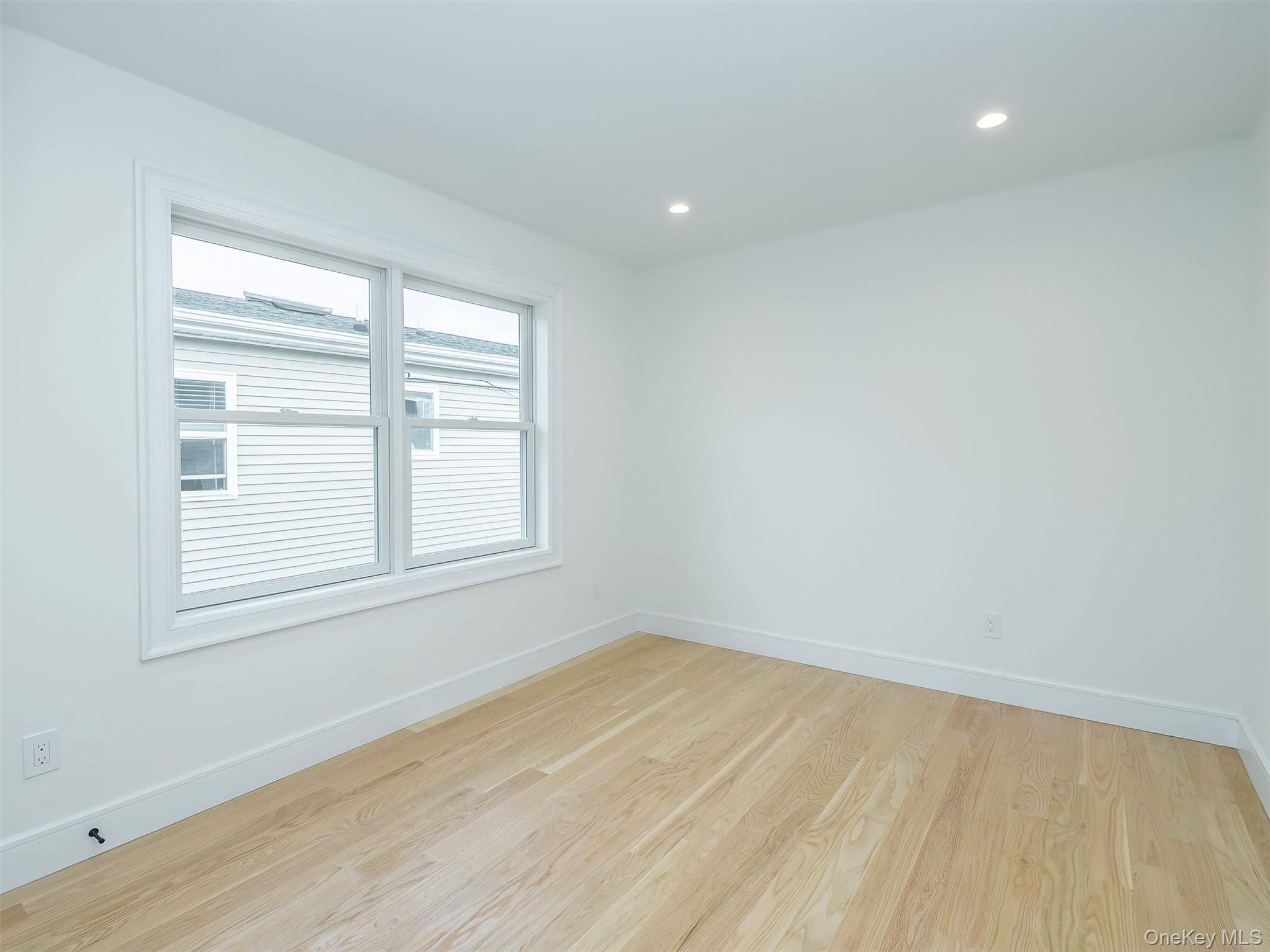 35 B Dunwood Road Port Washington, NY 11050 - Photo 25 of 35 an empty room with wooden floor and windows