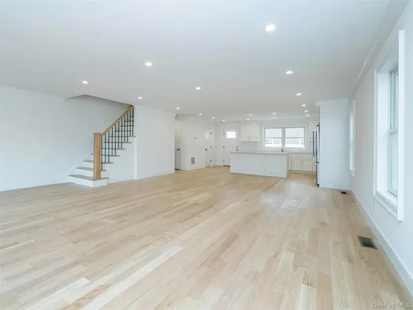 a kitchen with stainless steel appliances kitchen island a refrigerator sink and white cabinets